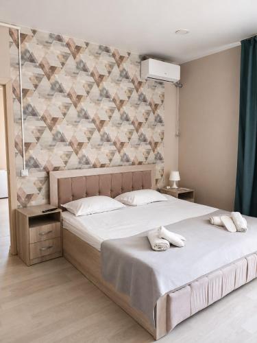 a bedroom with a large bed and a wall at Terra Hotel in Berezovka