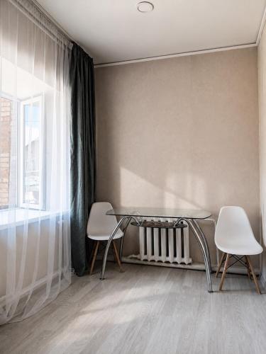a dining room with a glass table and two chairs at Terra Hotel in Berezovka