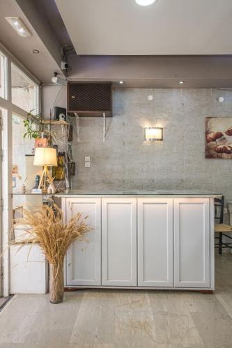 a kitchen with white cabinets and a brick wall at Bikakis Family Apartments in Kissamos
