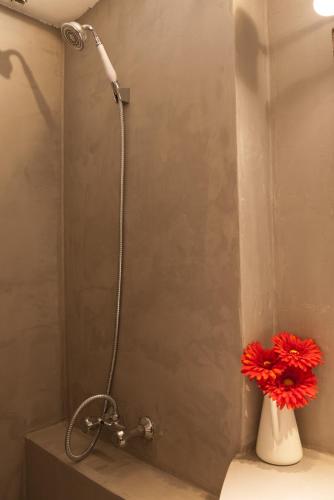 une douche avec une fleur rouge dans un vase blanc dans l'établissement La maison de Fanny, à Arles