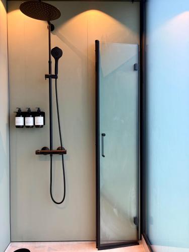 a shower in a bathroom with a glass door at Brennvika Panorama in Hamarøya