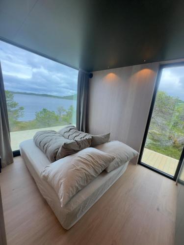 a bedroom with three beds and a large window at Brennvika Panorama in Hamarøya