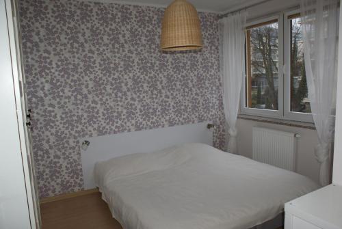 a small bedroom with a bed and a window at Nautilus 107 in Świnoujście