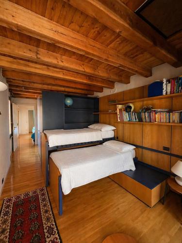 two beds in a room with wooden ceilings at Storico appartamento con parco in Sanguinetto