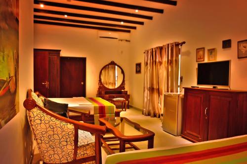 Una sala de estar con un sofá y un televisor. en Lucas, en Bentota