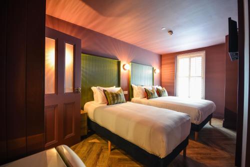 a room with two beds and a window at the Continental Boutique Residence in Galway