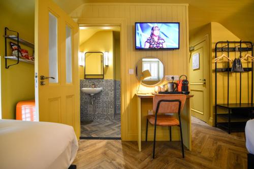 a hotel room with a bathroom with a sink and a television at the Continental Boutique Residence in Galway