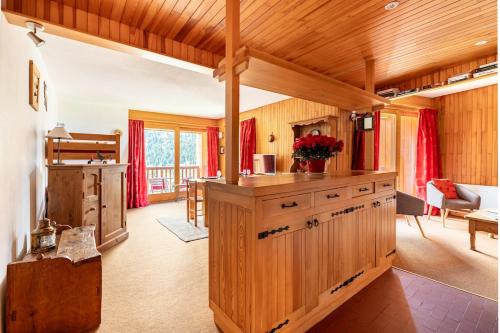 a kitchen with wooden cabinets and a living room at Large Méribel Three Valleys in Les Allues