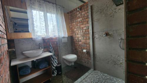 a bathroom with a sink and a toilet and a window at Kairos Vista in Sedgefield