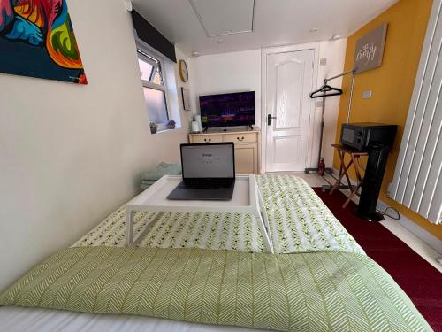 a bed with a laptop on it in a room at Private Guest Suite in Bletchley, Milton Keynes in Bletchley