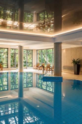 a large swimming pool in a large building at Hotel Nowy Dwór Elizy blisko Sky Bridge in Długopole-Zdrój