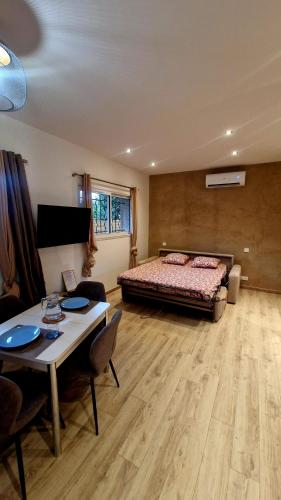 a bedroom with a bed and a table and a dining room at Studio cosy avec jacuzzi , sauna et salle de sport in Vallauris