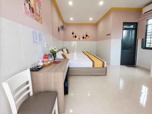 a kitchen with a desk and a bed in a room at Viora Hotel in Ấp Phước Thiện