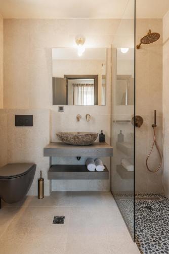 a bathroom with a sink and a toilet and a shower at Villa Thalassa by Villa Select in Fiskardo