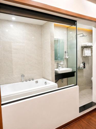 a bathroom with a white tub and a sink at A25 Premium Hotel - 21 Nghia Tan in Hanoi