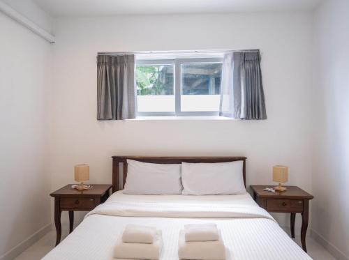 a bedroom with a bed with two nightstands and a window at Baan Iris 2Br Private Pool & Sunrise Deck in Chaweng