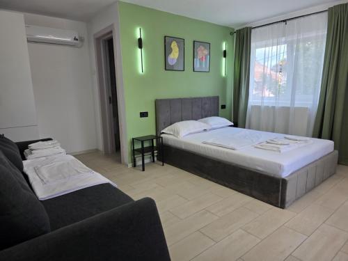 a bedroom with two beds and a couch at Urban Nest in Călimăneşti