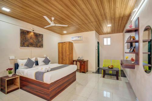 a bedroom with a bed with a wooden ceiling at Falcon's Retreat in Pune