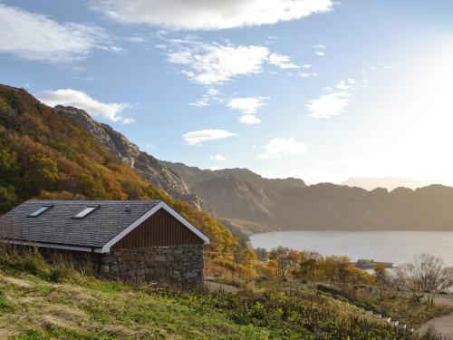 an old barn on a hill with a lake at Mango Pony's Bothy - Uk31959 in Dibaig