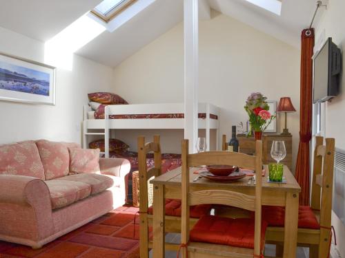 a living room with a couch and a table at Mango Pony's Bothy - Uk31959 in Dibaig