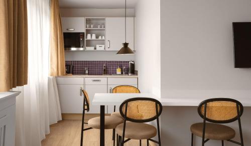 a kitchen with a white table and chairs at Limehome Berlin Chausseestraße in Berlin