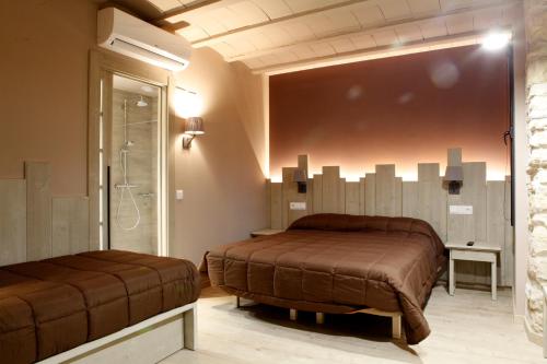 a bedroom with two beds and a shower at Cal Miqueló 1778 in Puig-Gros