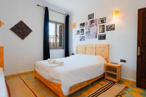 a bedroom with a bed and pictures on the wall at Palais Taroudant in Taroudant