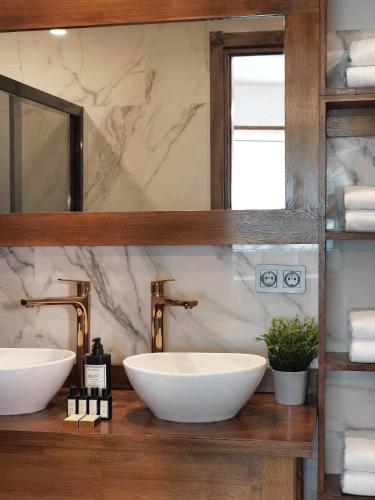 a bathroom with two sinks and a mirror at Triangulo Hotel in Alaçatı