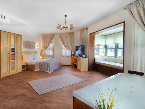 a large room with two beds and a tub at Triangulo Hotel in Alaçatı