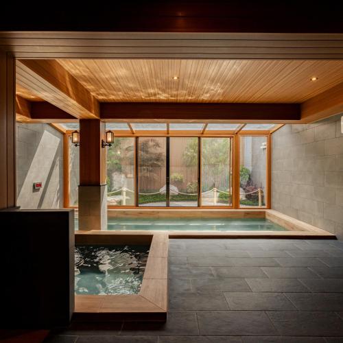 a swimming pool in a house with a large window at Zen Essence Khao Yai in Khao Yai