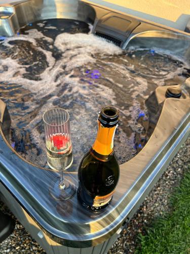 a hot tub with a bottle of wine and a glass at Host & Stay - Thistle Cottage in Rochester