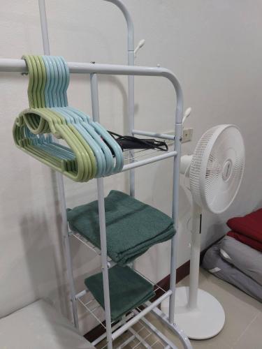 a towel rack with green towels and a fan at Meena Home Hatyai in Ban Khlong Hae