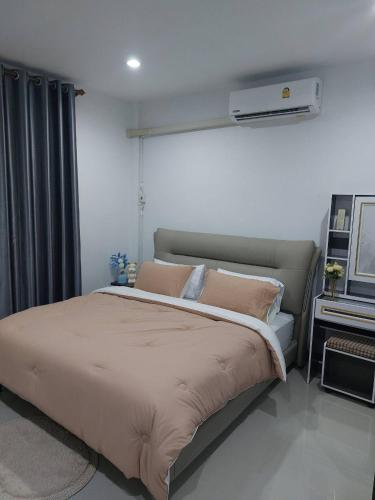 a bedroom with a large bed with pink pillows at Meena Home Hatyai in Ban Khlong Hae
