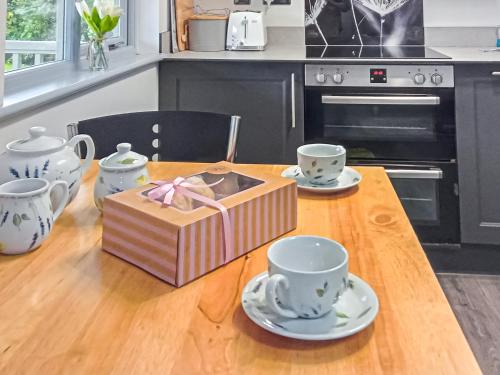 a wooden table with two cups and a box on it at The Pavilion in Swaton