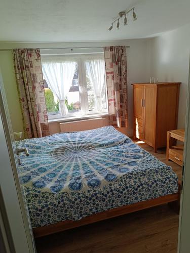 a bedroom with a bed with a blue comforter and two windows at Haus Berta in Spremberg