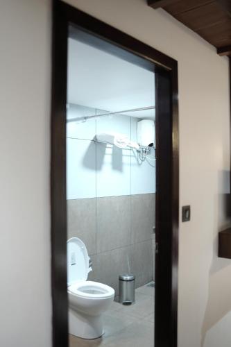 a bathroom with a toilet and a glass door at Suryamangalam Heritage in Cheruppulasseri