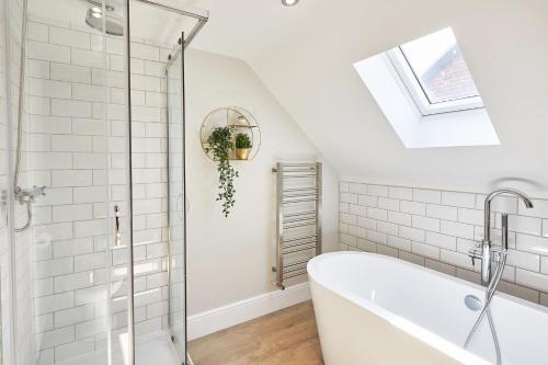 a bathroom with a white tub and a skylight at The Penthouse Retreat in Whitby