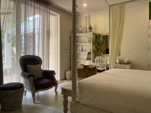 a bedroom with a bed and a chair and a window at O - HO Boutique Home in Ban Tai