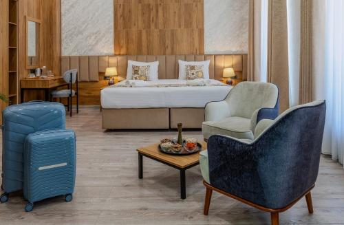 a hotel room with a bed and a chair and a table at Khan Hotel Bukhara Old Town in Bukhara
