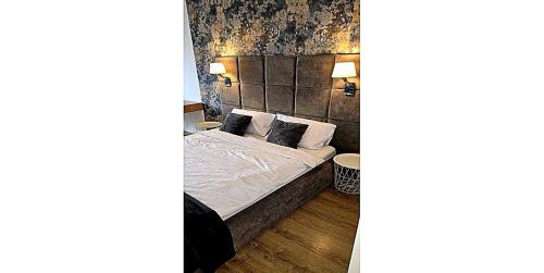 a bedroom with a bed with white sheets and pillows at Lumina OVO2 in Wrocław