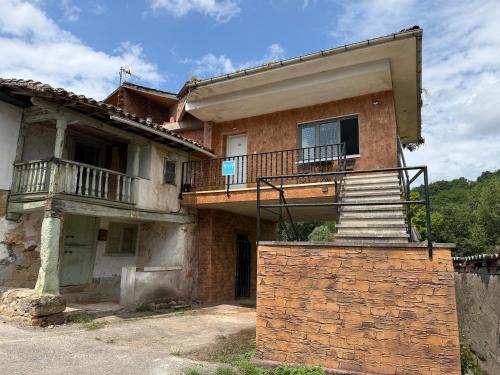 an old house with a balcony and stairs on it at La Caleya de Ozanes in Ozanes