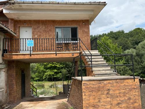 a brick house with a balcony and stairs at La Caleya de Ozanes in Ozanes
