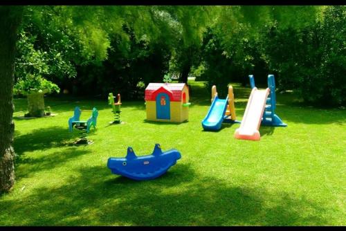 a playground with a slide and a play set in the grass at Apartamento Tomela in Noja