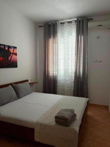 a bedroom with a large bed and a window at Kapo Residence in Vlorë