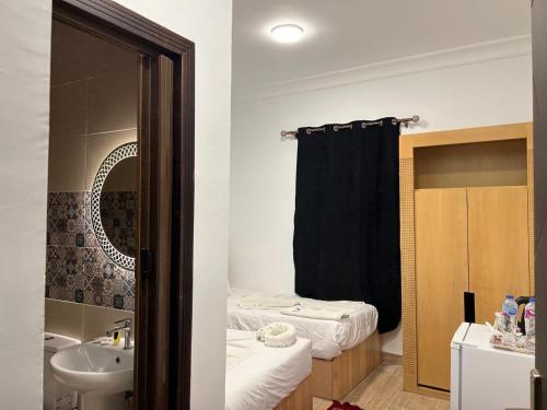 a bathroom with a bed and a sink and a mirror at Phoenix Pyramids Inn in Banī Ghālib