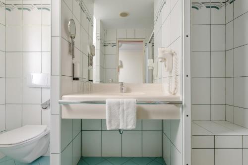 a bathroom with a sink and a toilet at Hotel PALACE in Bad Hofgastein