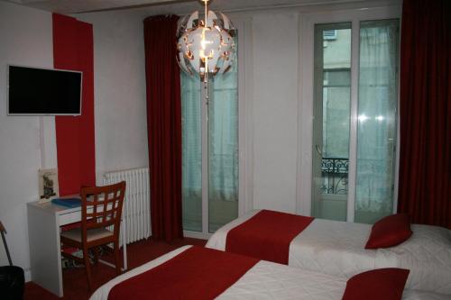 a hotel room with two beds and a desk and a television at Hôtel Le Chambellan in Dijon