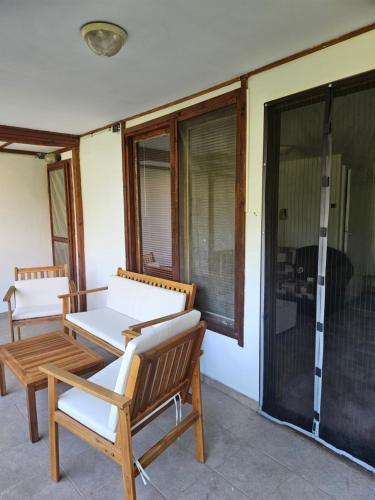 a patio with two chairs and a table on a porch at Къщи за гости Кедър in Varna City