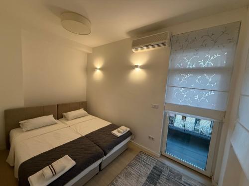 a small bedroom with a bed and a window at BASC Modern 2 in Sarajevo