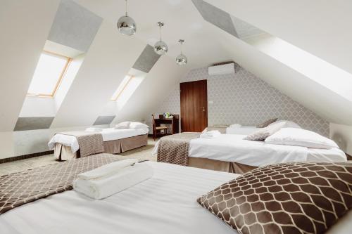 a attic room with three beds and a staircase at Hotel Fero Express POKOJE KLIMATYZOWANE AC in Krakow